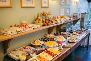 a buffet line with many different types of food at Lê Château Hotel de Gramado, seu refúgio no centro da cidade in Gramado
