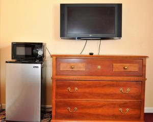 a television sitting on top of a dresser with a microwave at A Nights Inn in Ridgecrest