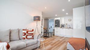 a living room with a couch and a kitchen at Stā by The Bridge, Inverness City Centre in Inverness