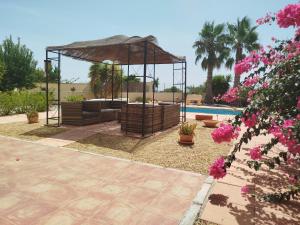 a gazebo and a pool with pink flowers at La Casa Montana in Urcal