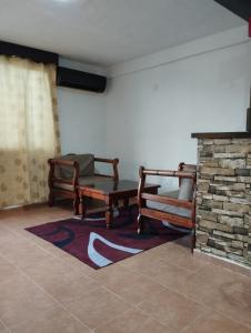 a living room with two chairs and a fireplace at nuevo y comodo departamento in Mérida