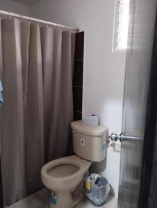 a bathroom with a toilet with a shower curtain at nuevo y comodo departamento in Mérida