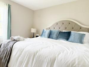 Un dormitorio con una gran cama blanca con almohadas azules. en 5th Street Retreat - KING 1BD-1BA Apt in Henderson, en Henderson