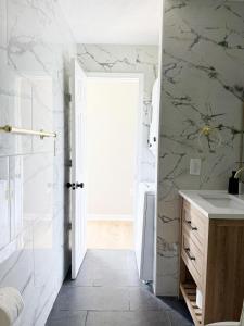 baño con lavabo y ducha con paredes de mármol en 5th Street Retreat - KING 1BD-1BA Apt in Henderson, en Henderson