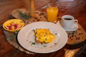 a table with a plate of food and a cup of orange juice at Tinamú Birding and Nature Lodge in Manizales