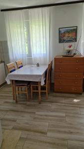 a dining room with a table and chairs and a dresser at Domacinstvo Ubovic in Šipovo +24 photos
