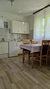 a kitchen with a table and chairs and a kitchen with white cabinets at Domacinstvo Ubovic in Šipovo
