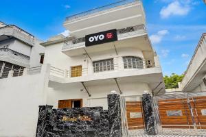 a white building with a qo sign on it at SPOT ON Manjuvilla in Varanasi