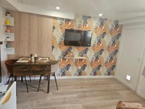 a room with a table and a tv on a wall at Maison Ethno Chic proche de Paris et d'Orly in Morangis