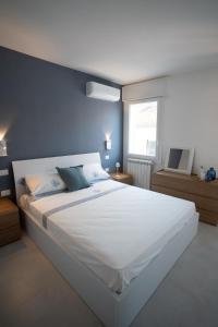 a bedroom with a large white bed with a blue wall at Ca' Cesarino in Chioggia