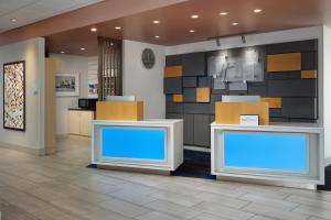 a lobby with two counters with blue screens at Holiday Inn Express & Suites Brunswick by IHG in Brunswick +24 photos