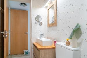 a bathroom with a sink and a toilet and a mirror at Terrassa de Mar Apartment in Masnou +42 photos