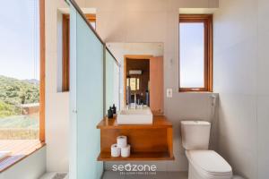 une salle de bain avec un lavabo, des toilettes et un miroir dans l'établissement Cabana de luxo na Serra Catarinense VST018, à São Paulo dos Pinhais