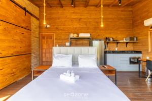 Cette chambre en bois comprend un lit blanc. dans l'établissement Cabana de luxo na Serra Catarinense VST018, à São Paulo dos Pinhais