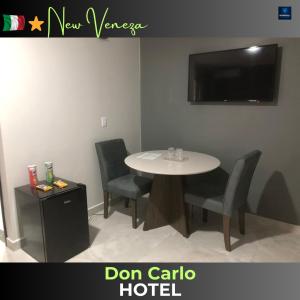 a room with a table and chairs and a tv at Don Carlo Hotel in São Bernardo do Campo