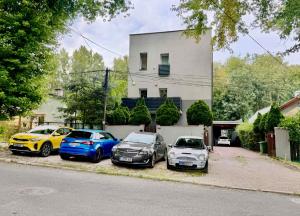 a group of three cars parked in front of a house at GOOD APART APARTAMENTY 3 SYPIALNIE PARKINg in Łódź