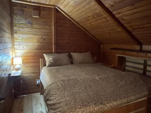 a bed in a cabin with a wooden wall at Knez in Smederevo