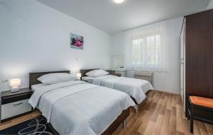 twee bedden in een kamer met witte muren en houten vloeren bij Villa Roko in Barban +18 foto's