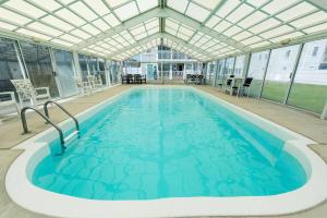 a large swimming pool with a glass ceiling at By the Sea in Kill Devil Hills