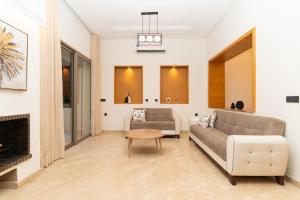 ein Wohnzimmer mit Couch und Kamin in der Unterkunft Villa Meraki in Marrakesch + 72 Fotos