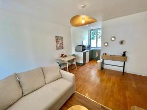 a living room with a couch and a table at Appartment Mal coiffé in Moulins
