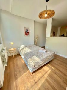 a bedroom with a bed and a wooden floor at Appartment Mal coiffé in Moulins