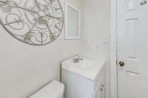 a white bathroom with a sink and a mirror at 6 Mi to Museum of Aviation Rural Kathleen Home in Bonaire +17 photos