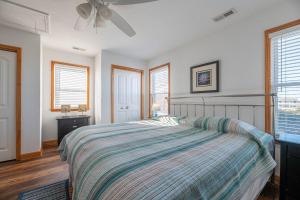 une chambre avec un lit et un ventilateur de plafond dans l'établissement Carolina Cottage, à Kitty Hawk 97 autres photos