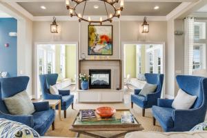 a living room with blue chairs and a fireplace at Millville by the Sea --- 36682 Calm Water Dr in Millville