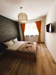 een slaapkamer met een bed en een groot raam bij DIN Residence in Braşov