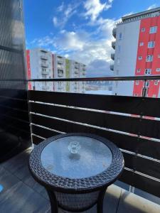een tafel met een wijnglas bovenop een balkon bij DIN Residence in Braşov