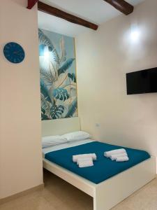 a bed in a room with a clock on the wall at TiTò Apartment in Naples