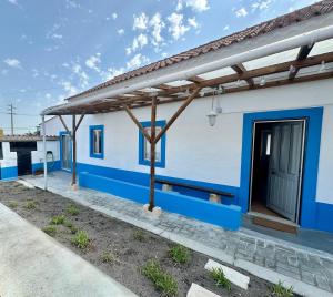 a blue and white house with a blue door at Casal do Pequeno in Alcobaça