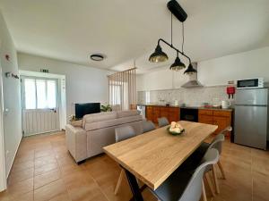 a kitchen and living room with a table and a couch at Casal do Pequeno in Alcobaça