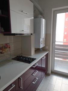 een keuken met witte apparatuur en een raam bij DIN Residence in Braşov