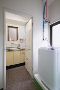 a kitchen with a sink and a refrigerator at Dormitory サークルテン- Share Room For Male Only 男性専用ドミトリー in Tokyo