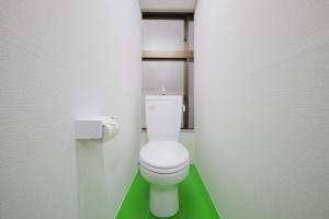 Un baño con un inodoro blanco con suelo verde. en Dormitory サークルテン- Share Room For Male Only 男性専用ドミトリー, en Tokio 41 fotos más