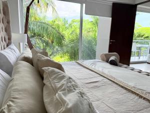 a large bed in a room with a large window at BOLONGO: your exclusive oceanfront escape in Higuera Blanca