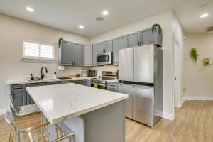 una cocina con electrodomésticos de acero inoxidable y armarios grises en Walk to Carrollton Ave Eats Bright NOLA Duplex!, en Nueva Orleans 16 fotos más
