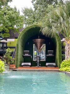 a pool with two chairs and a chandelier at Luxury 1br Retreat W Private Patio & Courtyard in Dallas