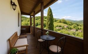 a balcony with a table and chairs and a view at Casona Sariego in Riosa