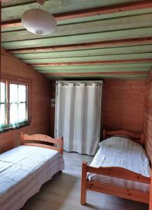a bedroom with two beds in a log cabin at Pause nature au cœur des forêts in Saint-Pal-de-Senouire