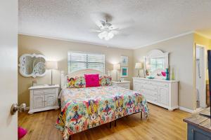 een slaapkamer met een bed en twee dressoirs en spiegels bij Seashell 20 in Clearwater Beach
