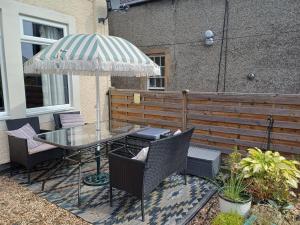 a patio with a table and chairs and an umbrella at The Hideaway in Peebles