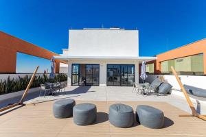 a building with a patio with blue chairs and umbrellas at MUV Residence - Centro | Gonzaga Stays in Curitiba