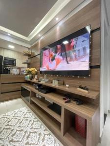 a living room with a large flat screen tv at Apartamento no centro de Hortolândia e a 5 minutos de Sumaré in Hortolândia +13 photos