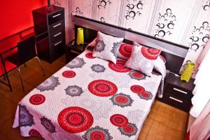 1 dormitorio con 1 cama con edredón y almohadas en PR Plaza de Galicia, en Santiago de Compostela