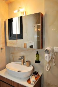a bathroom with a sink and a mirror at Meteora Guest Houses in Kalabaka