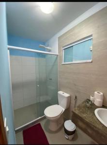 a bathroom with a toilet and a shower and a sink at Pousada Preciosa in Búzios