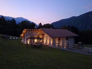a building with lights on it in a field at Country Life Chalet in Tione di Trento